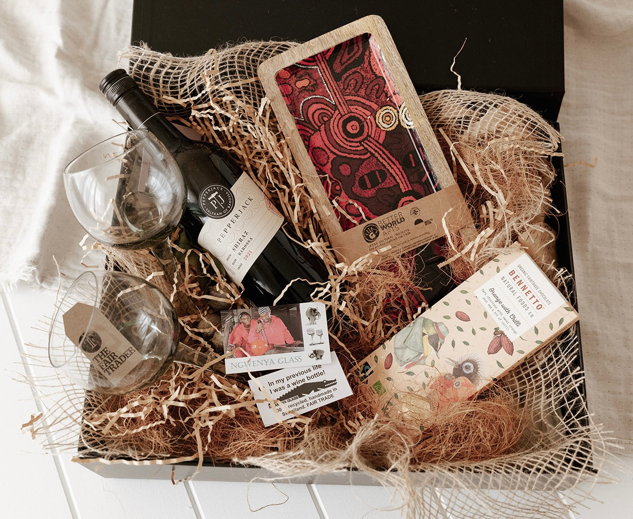 Melbourne corporate hamper - red wine, eco friendly wine glasses, Indigenous art wooden plate, Fairtrade chocolate in sustainable gift box