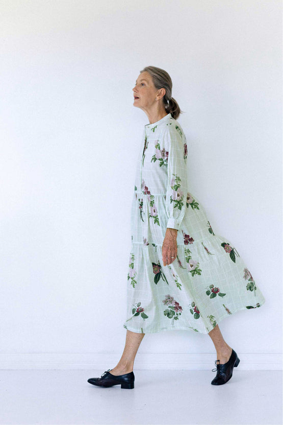 Floral print pale green midi dress, worn with black brogues. The model is walking to the left