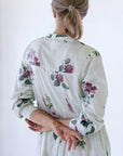 Floral print pale green midi dress, photo shows the back of the garment. Full length sleeves slightly pushed up