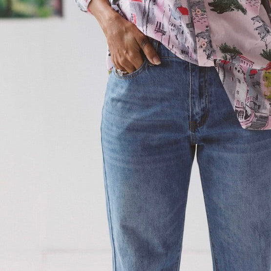 Blue washed boyfriend jeans by Lazybones. Woman wears jeans with printed shirt and has her hand in the front pocket. | Ethical Australian fashion brand