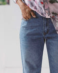 Blue washed boyfriend jeans by Lazybones. Woman wears jeans with printed shirt and has her hand in the front pocket. | Ethical Australian fashion brand